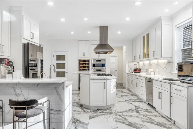 a kitchen with stainless steel appliances kitchen island granite countertop a sink and cabinets