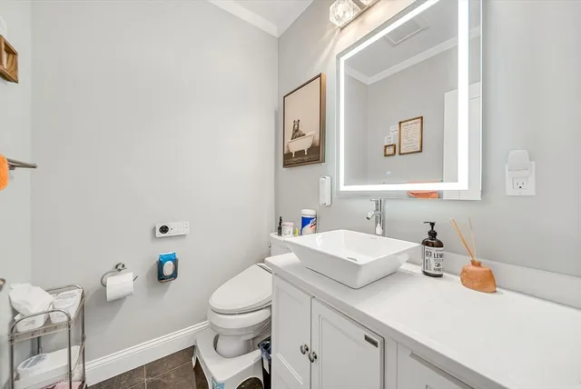 a bathroom with a sink a toilet and mirror