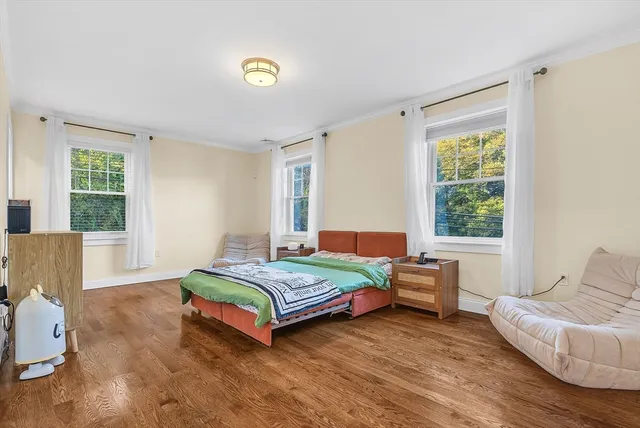 a bedroom with a bed and wooden floor