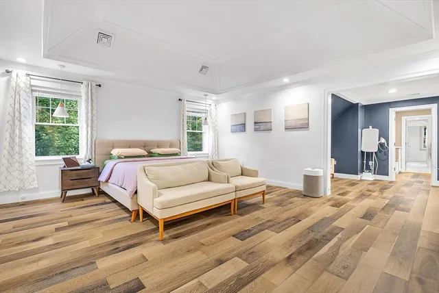 a bedroom with a bed wooden floor and window