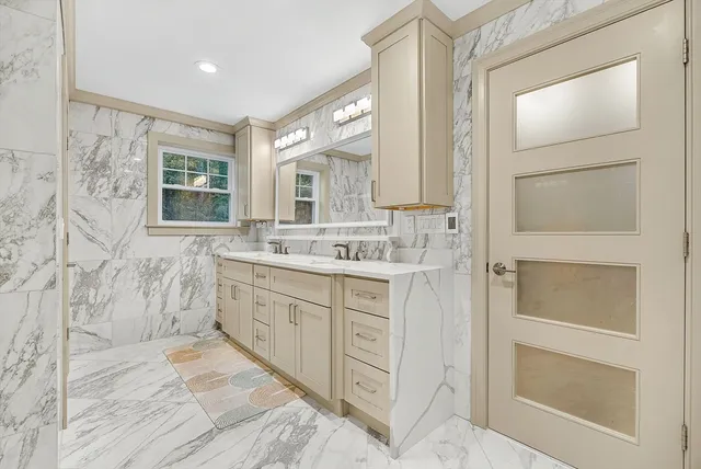 a spacious bathroom with a double vanity sink a mirror and a shower