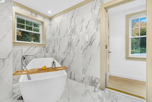 a bathroom with a tub and a window