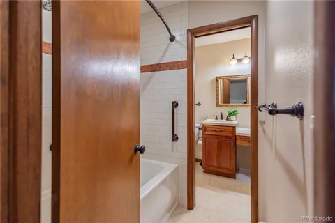 a bathroom with a tub sink and mirror