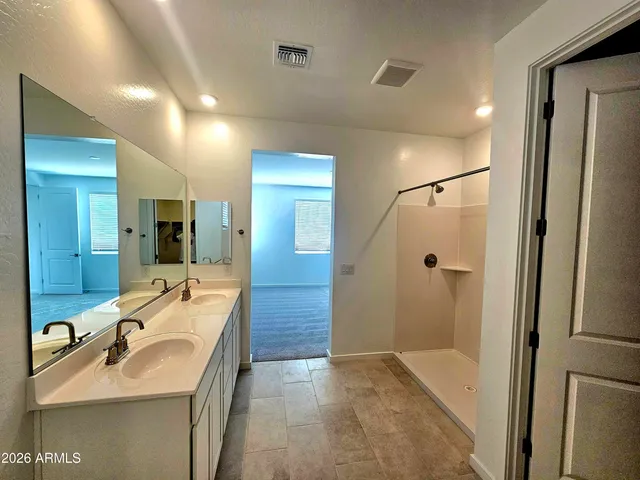 a bathroom with a double vanity sink toilet and shower