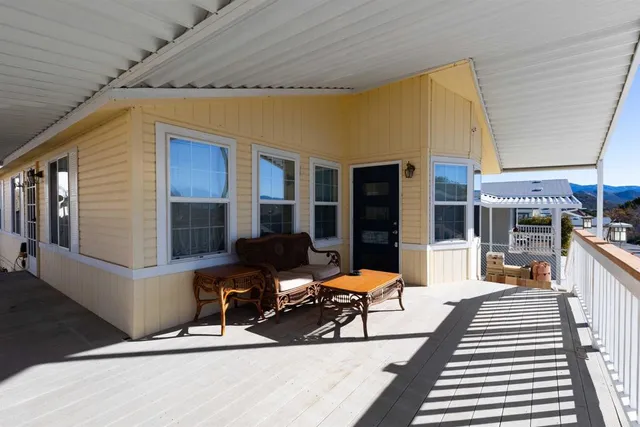 a view of a patio with table and chairs and barbeque