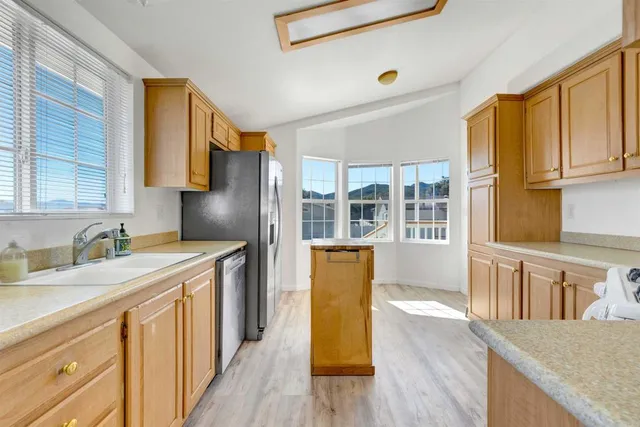 a kitchen with stainless steel appliances granite countertop a sink a stove and a refrigerator