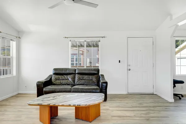 a spacious bedroom with a bed a couch and a chandelier
