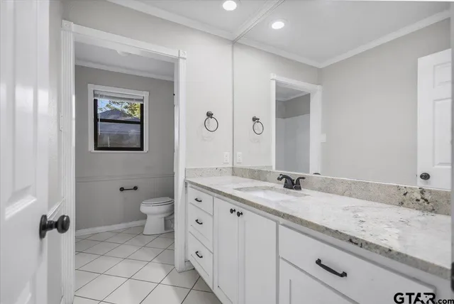 a view of an empty room with wooden floor and a ceiling fan