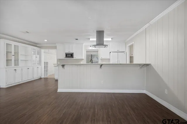 a kitchen with granite countertop white cabinets and white appliances