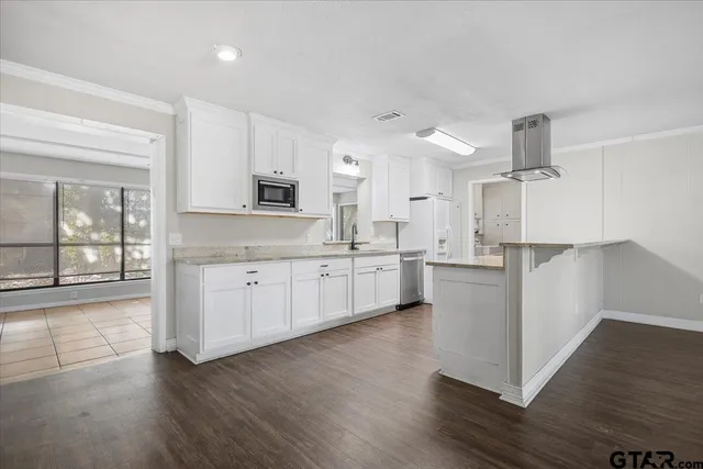 a kitchen with a stove cabinets and wooden floor