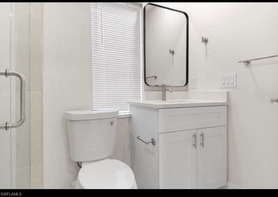 2619 23rd Street Southwest Lehigh Acres, FL 33976 - Photo 20 of 21 a bathroom with a toilet sink and mirror