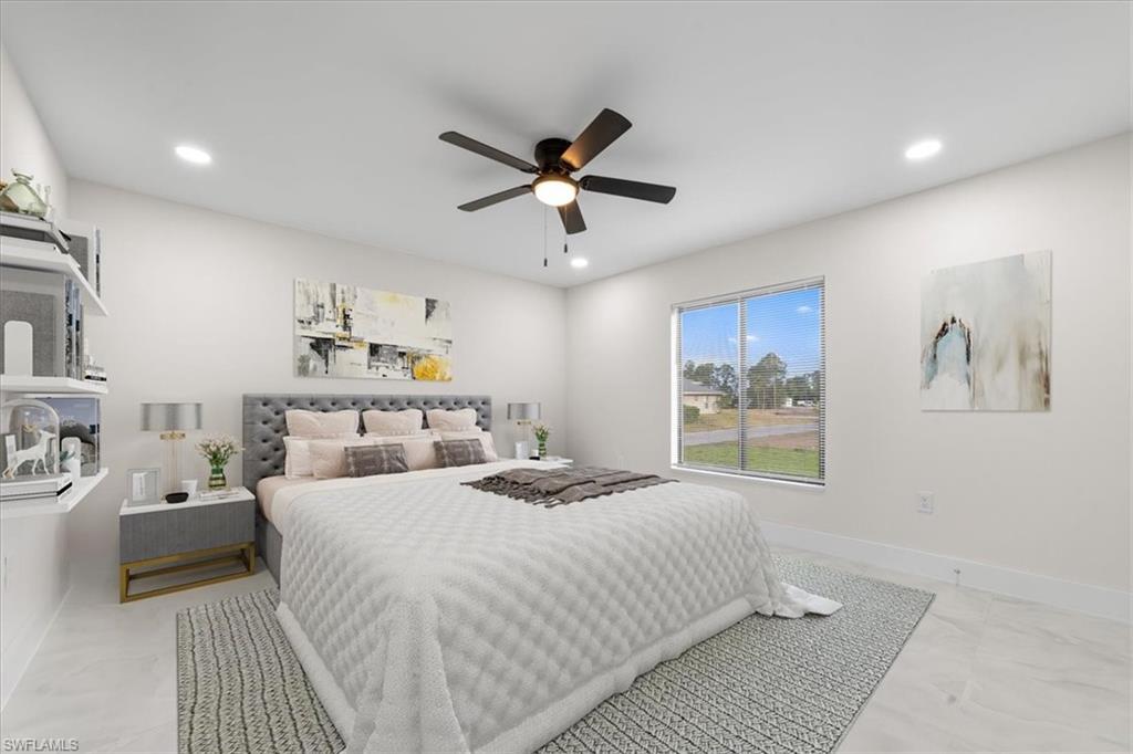 2619 23rd Street Southwest Lehigh Acres, FL 33976 - Photo 8 of 21 a bedroom with a bed and a chandelier