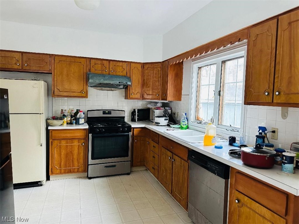 Kitchen with light tile floors, stainless steel appliances, and​​‌​​​​‌​​‌‌​‌‌​​‌​​​​‌​​​‌‌​‌‌‌ backsplash