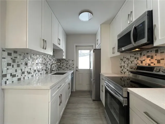 a kitchen with stainless steel appliances a stove microwave and refrigerator