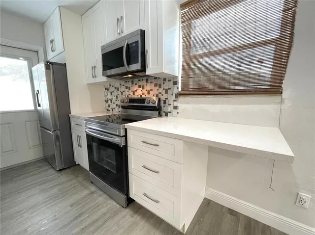 a kitchen with stainless steel appliances a stove microwave and a refrigerator