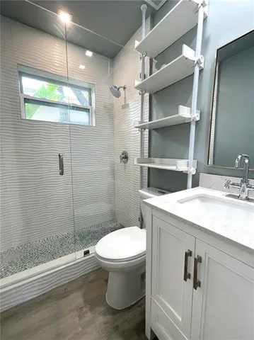 a bathroom with a sink a toilet and shower