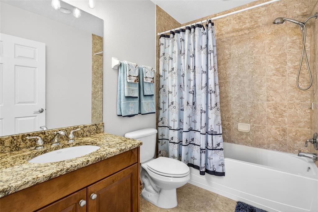 17717 Gulf Boulevard, Unit 401 Redington Shores, FL 33708 - Photo 20 of 66 a bathroom with a granite countertop sink toilet and shower