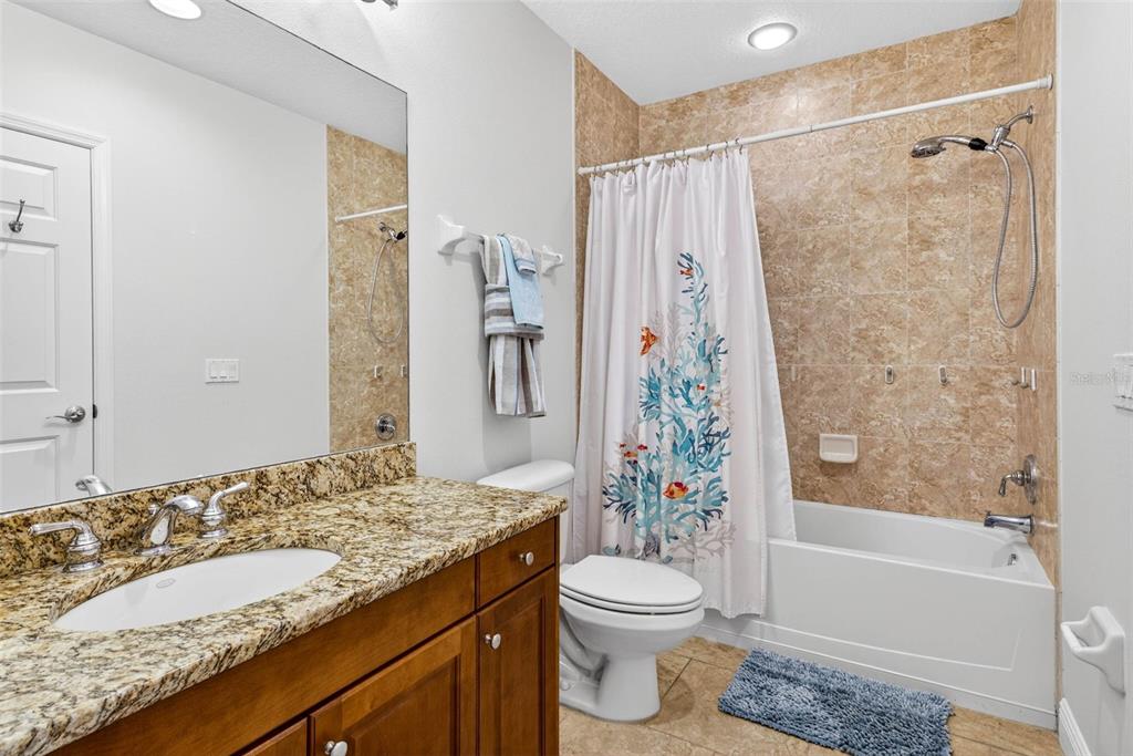 17717 Gulf Boulevard, Unit 401 Redington Shores, FL 33708 - Photo 24 of 66 a bathroom with a granite countertop sink toilet and shower