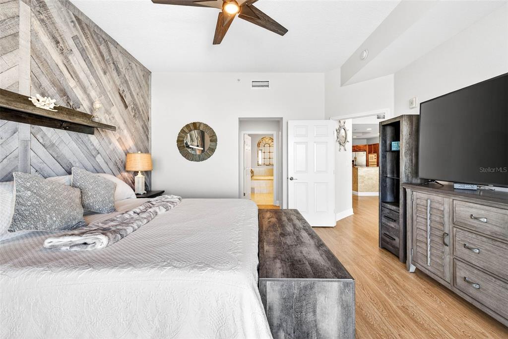 17717 Gulf Boulevard, Unit 401 Redington Shores, FL 33708 - Photo 29 of 66 a bedroom with a bed and a flat tv screen on dresser