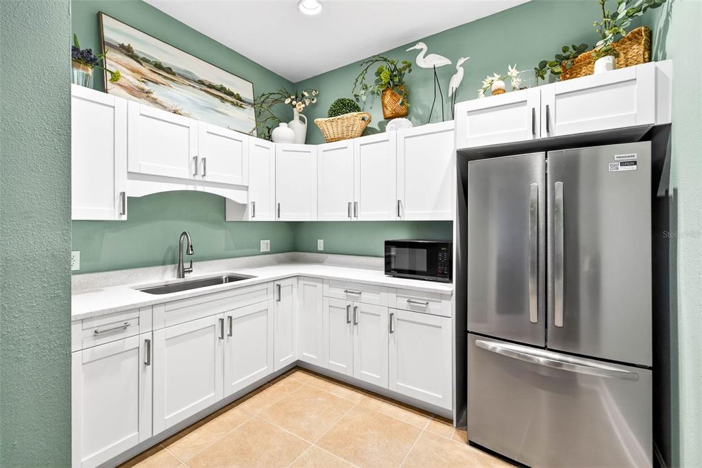 17717 Gulf Boulevard, Unit 401 Redington Shores, FL 33708 - Photo 51 of 66 a kitchen with stainless steel appliances a refrigerator sink and cabinets