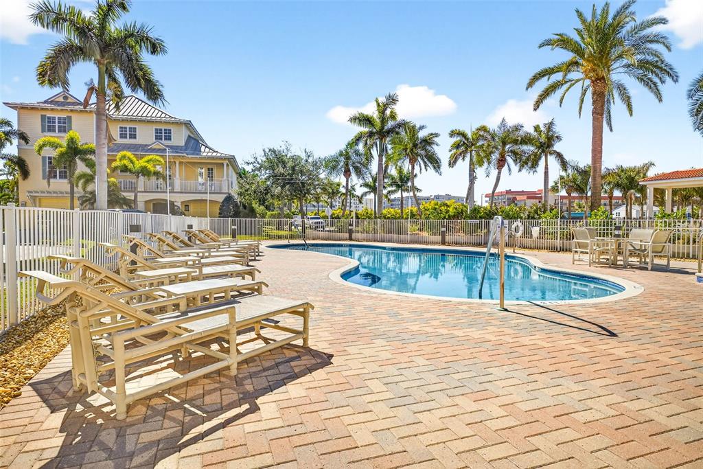17717 Gulf Boulevard, Unit 401 Redington Shores, FL 33708 - Photo 53 of 66 a view of swimming pool with outdoor seating and palm tree