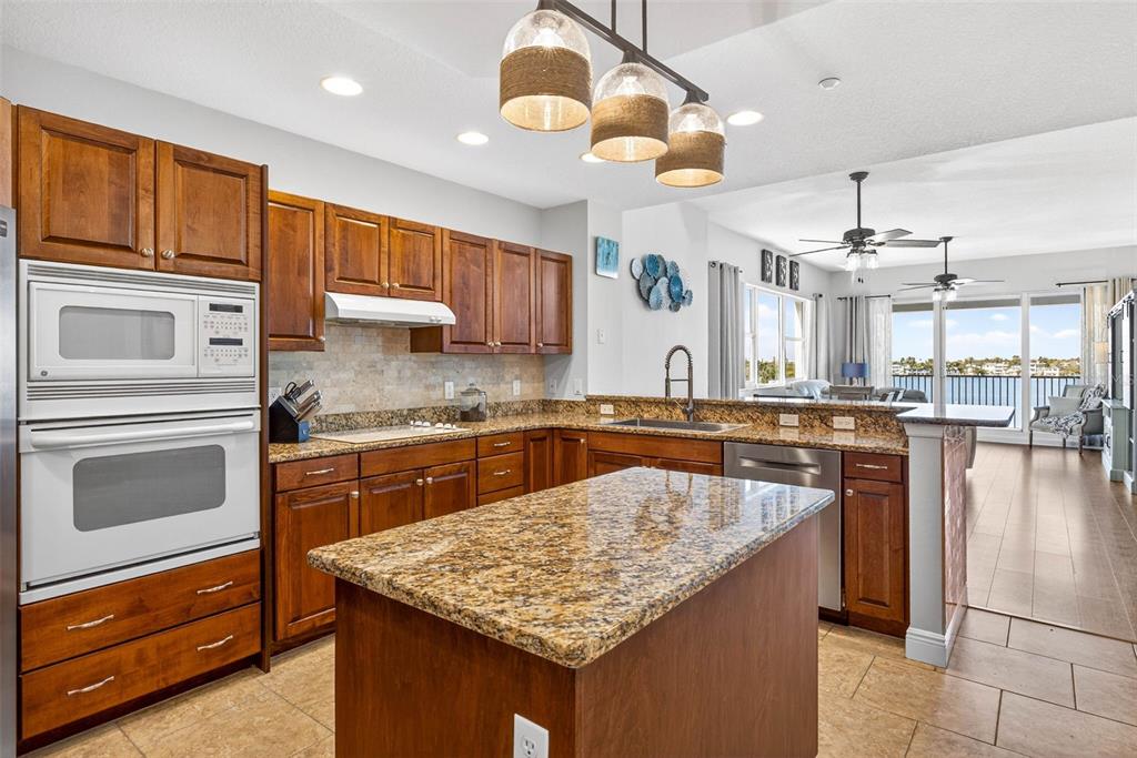 17717 Gulf Boulevard, Unit 401 Redington Shores, FL 33708 - Photo 8 of 66 a kitchen with stainless steel appliances granite countertop a kitchen island a stove and a sink