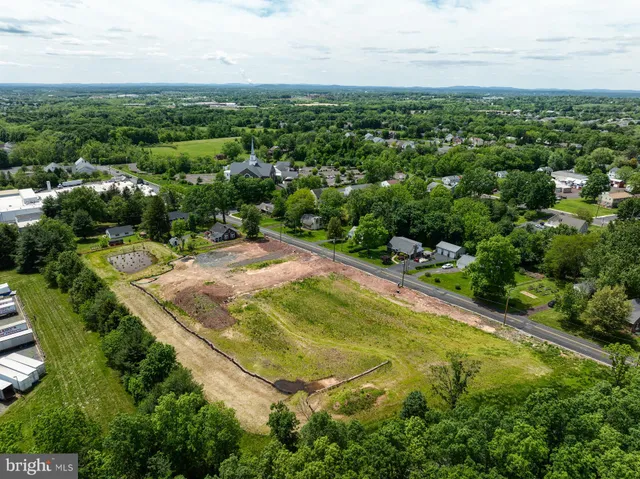 an aerial view of residential houses with outdoor space and trees