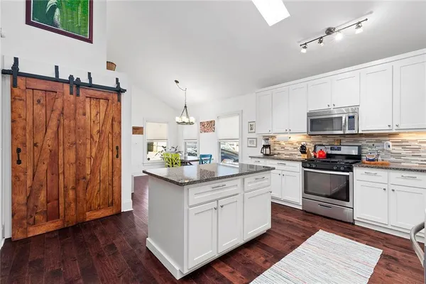 a kitchen with granite countertop stainless steel appliances and white cabinets