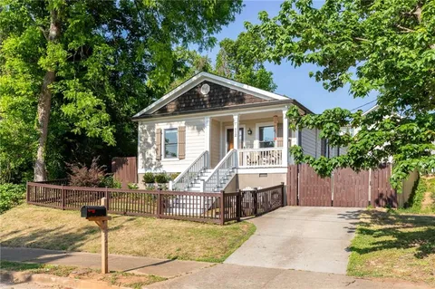 a view of a house with backyard and trees