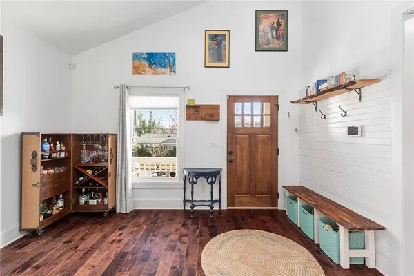 a kitchen with stainless steel appliances granite countertop a dining table chairs refrigerator and sink