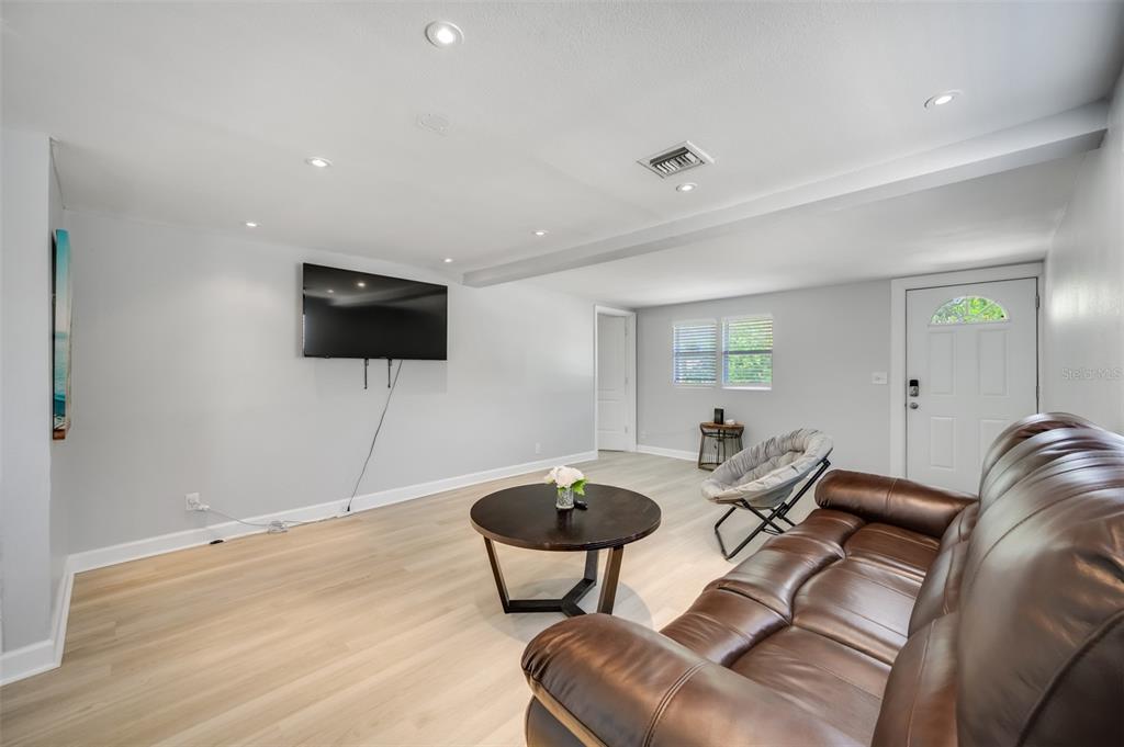 1601 Palm Way Largo, FL 33771 - Photo 5 of 25 a living room with furniture a flat screen tv and a wooden floor