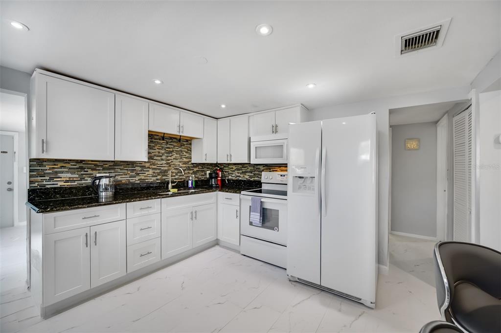 1601 Palm Way Largo, FL 33771 - Photo 9 of 25 a kitchen with white cabinets and white appliances
