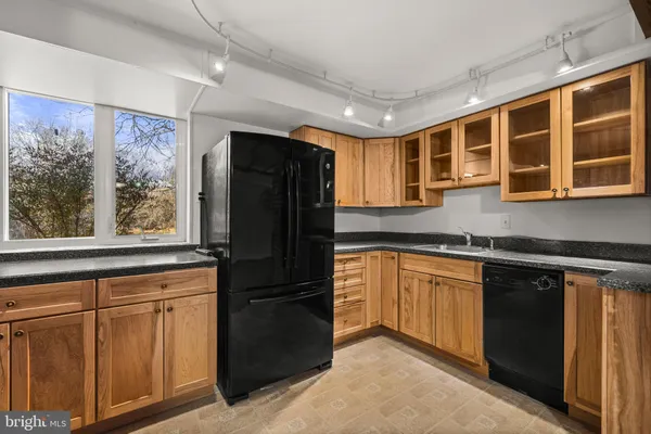 a kitchen with granite countertop white cabinets and a sink