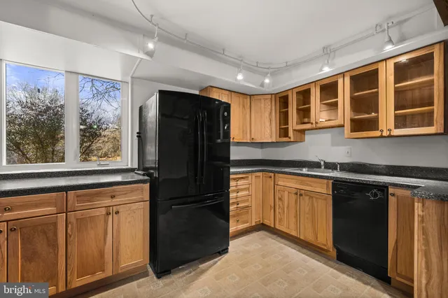 a kitchen with granite countertop white cabinets and a sink
