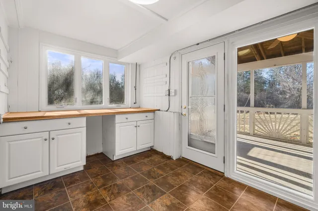 a view of backyard with wooden fence and large trees