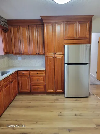 a kitchen with wooden cabinets and a refrigerator