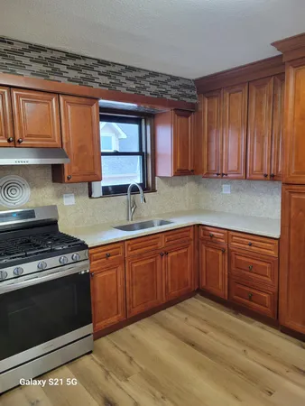 a kitchen with stainless steel appliances granite countertop wooden cabinets a sink and a stove