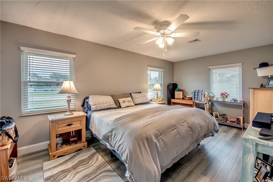 26508 Eager Road Punta Gorda, FL 33955 - Photo 24 of 41 a bedroom with bed and a chandelier