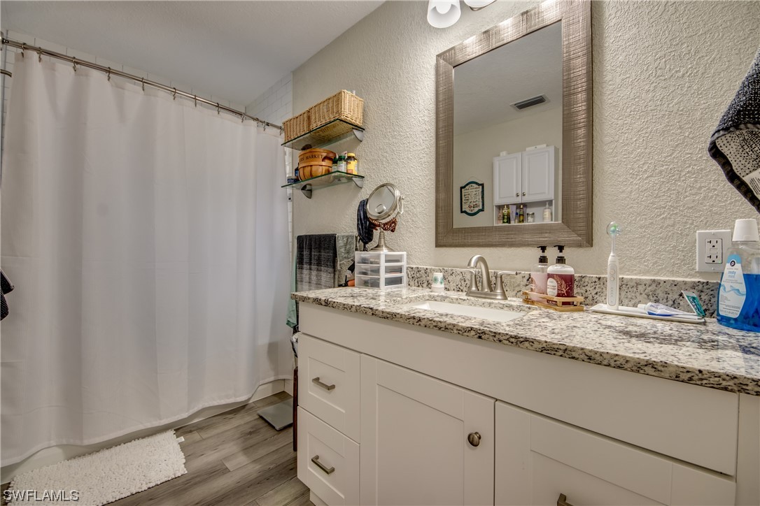 26508 Eager Road Punta Gorda, FL 33955 - Photo 28 of 41 a bathroom with a granite countertop sink and a mirror