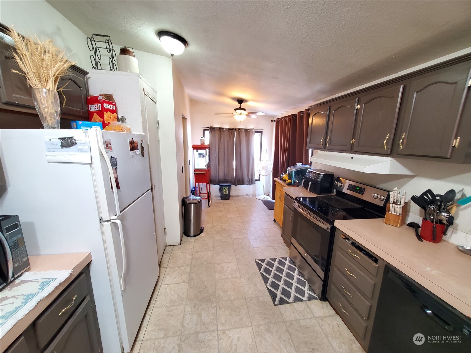 507 Mt Olive Road Riverside, WA 98849 - Photo 6 of 23 a kitchen with refrigerator a sink and cabinets