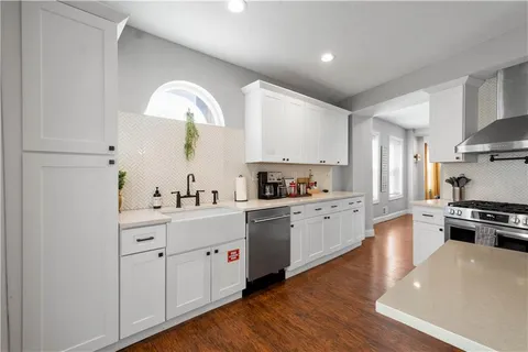 a kitchen with white cabinets stainless steel appliances and sink