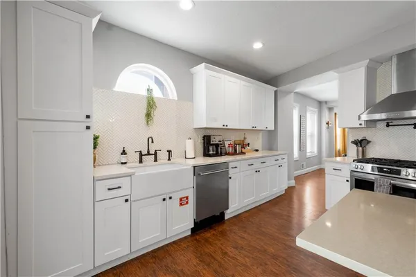a kitchen with white cabinets stainless steel appliances and sink