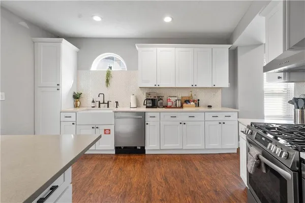 a kitchen with a sink a stove and cabinets