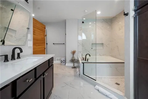 a bathroom with a sink a large mirror and a bathtub