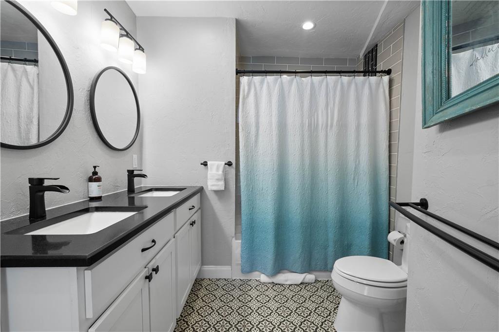 5101 Carnegie Street Pittsburgh, PA 15201 - Photo 29 of 34 a bathroom with a granite countertop toilet sink and mirror