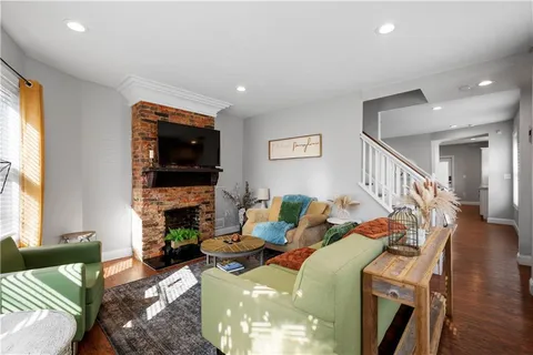 a living room with furniture a fireplace and a flat screen tv