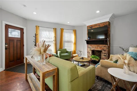 a living room with furniture a fireplace and a flat screen tv