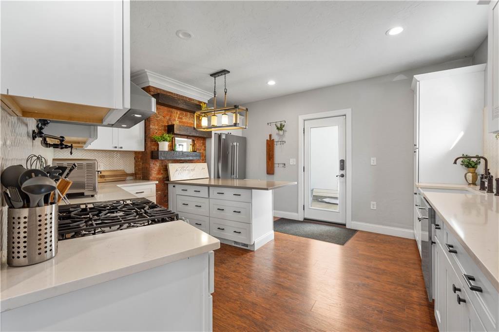5101 Carnegie Street Pittsburgh, PA 15201 - Photo 10 of 34 a kitchen with stainless steel appliances a stove a sink wooden floor and cabinets