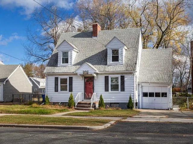 a view of a house with a big yard and large tree