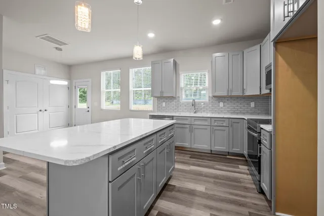 a kitchen with stainless steel appliances granite countertop a sink a stove a microwave and cabinets